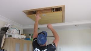 Man Folding Out Attic Ladder.