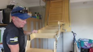 Man Folding Out Attic Ladder.